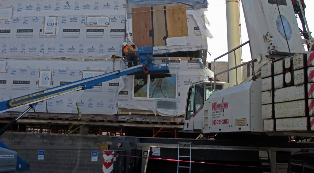 Crews lower pieces of an upcoming apartment building into place on Eliot Street. Photos by Aaron Kremer.