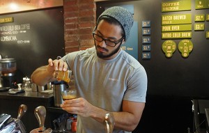 A Novo Coffee barista prepares a customer's drink. 