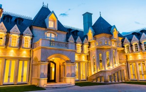 The limestone exterior of the U-shaped mansion is adorned with carved columns, stained glass, and statues on the top floor. (Courtesy LIV Sotheby's)