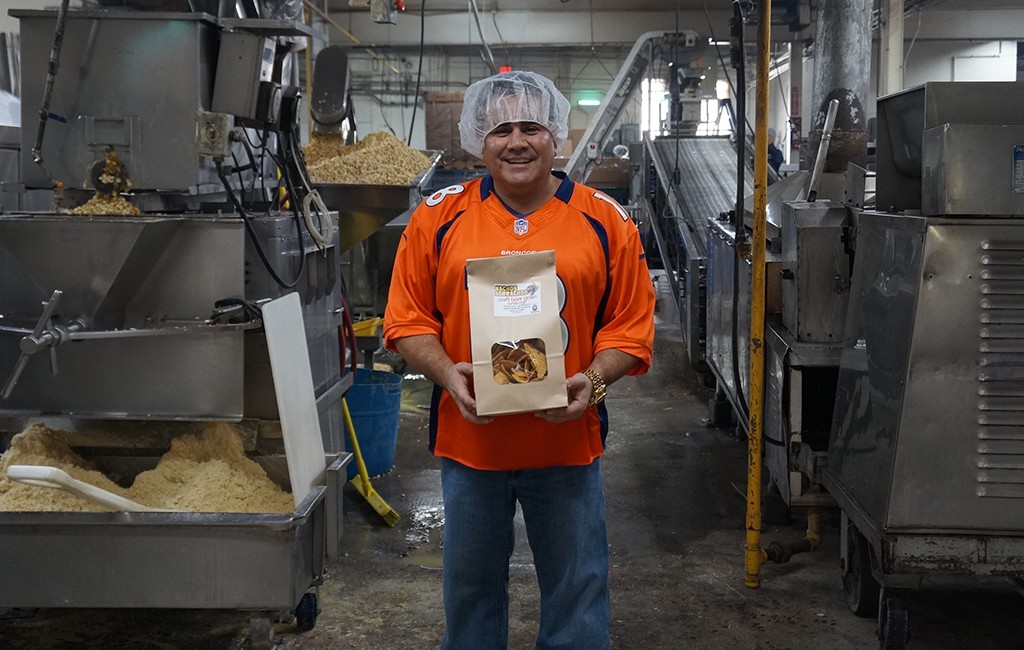 Rich Schneider holds a bag of tortilla chips in the manufacturing plant. (Amy DiPierro)