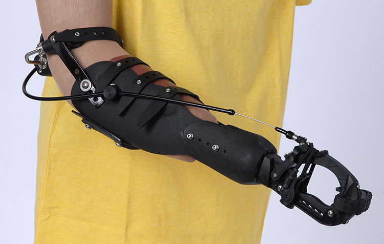 The prosthetic arm grasps objects with a cable system that harnesses an amputee's upper body muscles. (Courtesy ToughWare)