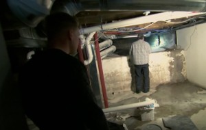 Nylund and a plumber assessing water damage on the episode. (DIY Network)